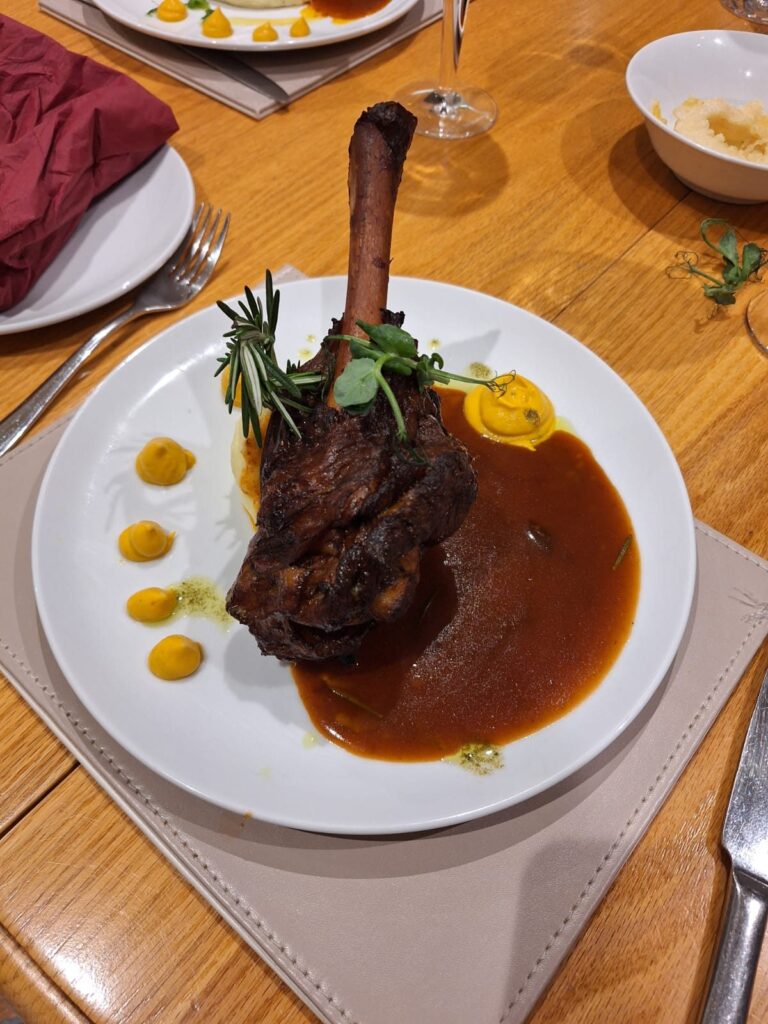 Braised lamb shank with jus, plated by Meals with Chef